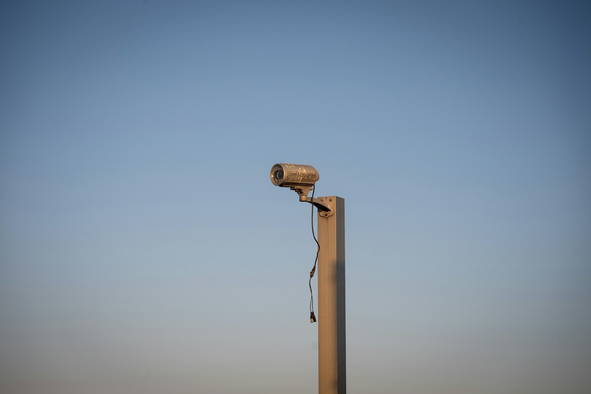 Commercial security camera mounted on a pole against blue sky