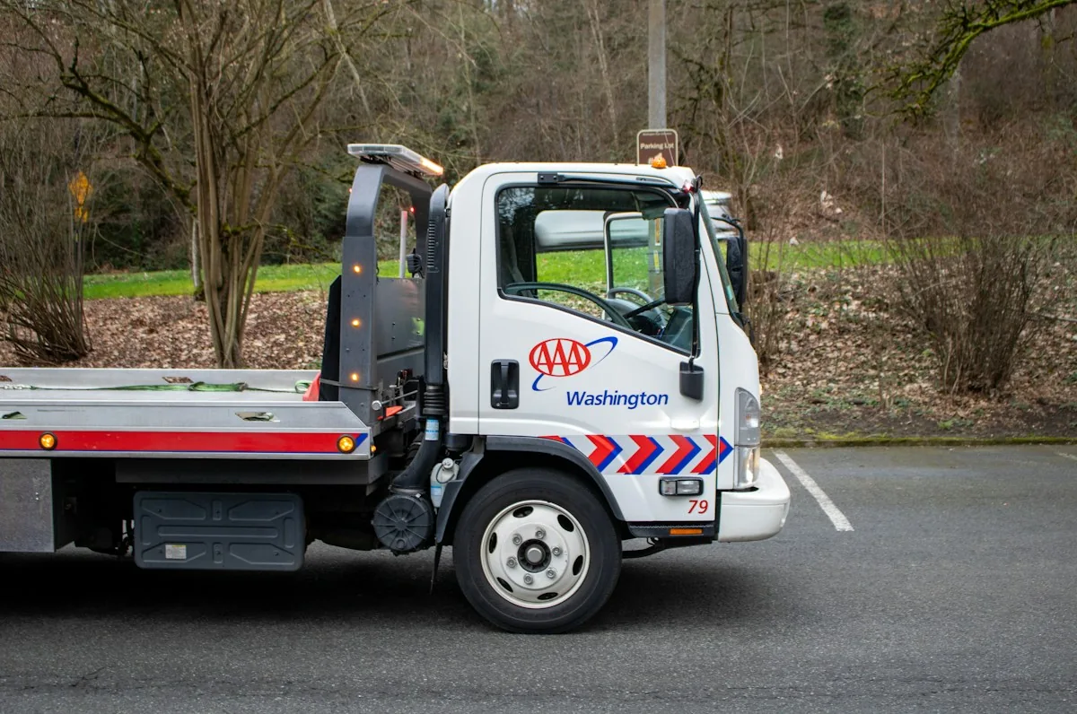 A parked white flatbed tow truck